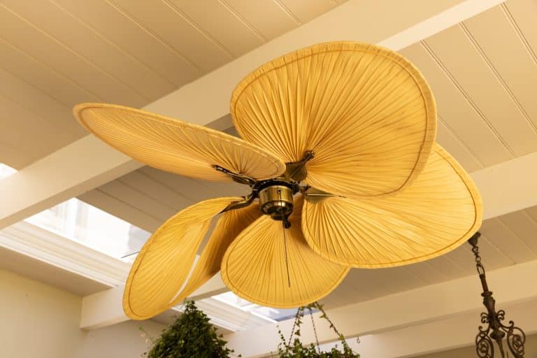 Close-up of decorative ceiling fan with leaf-shaped blades in modern home, copy space. Interior, design, furnishing, luxury, contemporary, stylish